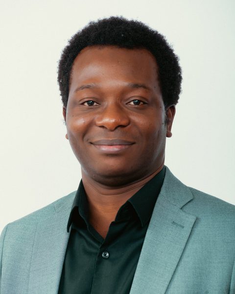 Dapo Bankole, founder of Mentorfy, smiling, in a sage-green blazer